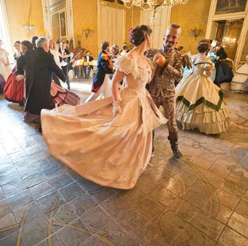 Une robe claire tournoie sur le parquet du Bal du Guépard